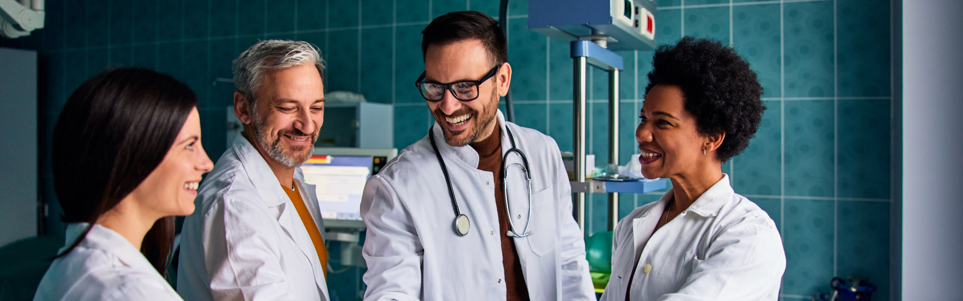 Adult and senior doctors with folded hands standing together in the hospital.